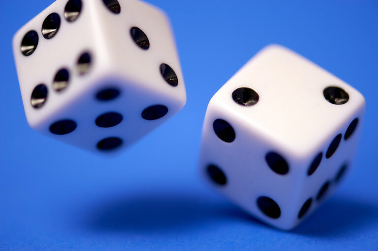 A pair of white dice on a blue background - FunFamilyGameNight.com